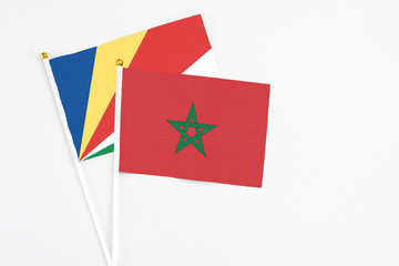 Morocco and Seychelles stick flags on white background. High quality fabric, miniature national flag. Peaceful global concept.White floor for copy space.v