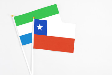 Chile and Sierra Leone stick flags on white background. High quality fabric, miniature national flag. Peaceful global concept.White floor for copy space.