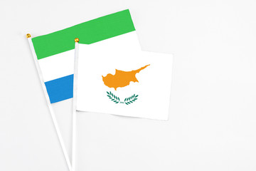 Cyprus and Sierra Leone stick flags on white background. High quality fabric, miniature national flag. Peaceful global concept.White floor for copy space.