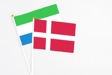 Denmark and Sierra Leone stick flags on white background. High quality fabric, miniature national flag. Peaceful global concept.White floor for copy space.