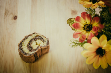 Fototapeta na wymiar cinnamon cake roll on wooden table in retro cafe