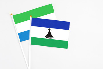 Lesotho and Sierra Leone stick flags on white background. High quality fabric, miniature national...