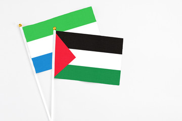 Palestine and Sierra Leone stick flags on white background. High quality fabric, miniature national...