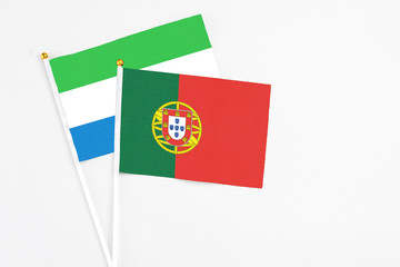 Portugal and Sierra Leone stick flags on white background. High quality fabric, miniature national flag. Peaceful global concept.White floor for copy space.