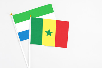 Senegal and Sierra Leone stick flags on white background. High quality fabric, miniature national...