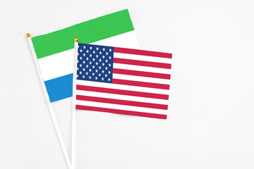United States and Sierra Leone stick flags on white background. High quality fabric, miniature national flag. Peaceful global concept.White floor for copy space.