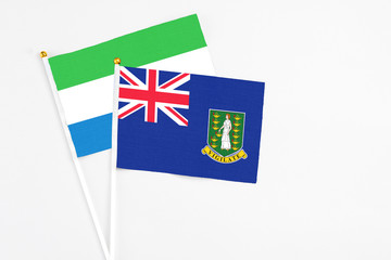 Fototapeta premium British Virgin Islands and Sierra Leone stick flags on white background. High quality fabric, miniature national flag. Peaceful global concept.White floor for copy space.