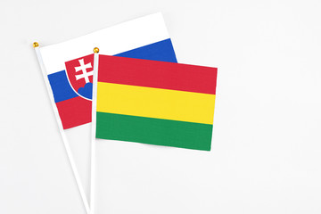 Bolivia and Slovakia stick flags on white background. High quality fabric, miniature national flag. Peaceful global concept.White floor for copy space.