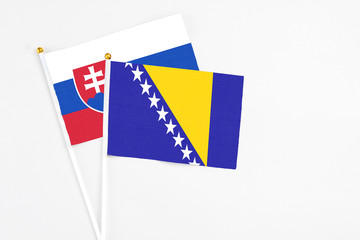 Bosnia Herzegovina and Slovakia stick flags on white background. High quality fabric, miniature...
