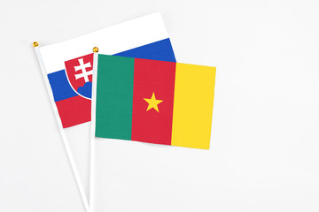 Cameroon and Slovakia stick flags on white background. High quality fabric, miniature national flag. Peaceful global concept.White floor for copy space.