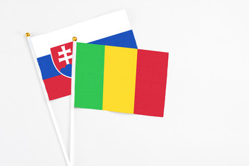 Mali and Slovakia stick flags on white background. High quality fabric, miniature national flag. Peaceful global concept.White floor for copy space.