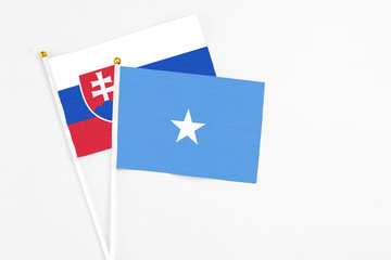 Somalia and Slovakia stick flags on white background. High quality fabric, miniature national flag. Peaceful global concept.White floor for copy space.