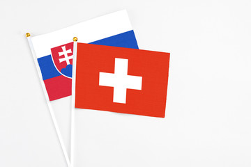 Switzerland and Slovakia stick flags on white background. High quality fabric, miniature national flag. Peaceful global concept.White floor for copy space.