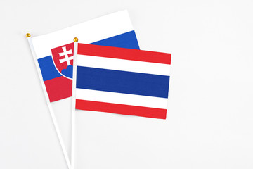 Thailand and Slovakia stick flags on white background. High quality fabric, miniature national flag. Peaceful global concept.White floor for copy space.