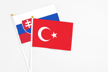 Turkey and Slovakia stick flags on white background. High quality fabric, miniature national flag. Peaceful global concept.White floor for copy space.