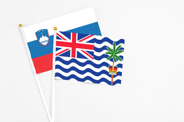 Fototapeta premium British Indian Ocean Territory and Slovenia stick flags on white background. High quality fabric, miniature national flag. Peaceful global concept.White floor for copy space.