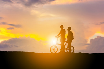 Fototapeta na wymiar Silhouettes of mother and son playing at sunset evening sky background.
