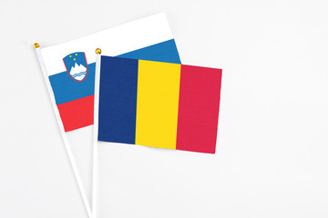 Chad and Slovenia stick flags on white background. High quality fabric, miniature national flag. Peaceful global concept.White floor for copy space.