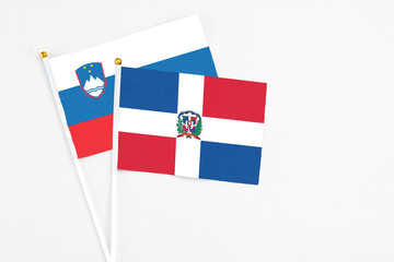 Dominican Republic and Slovenia stick flags on white background. High quality fabric, miniature national flag. Peaceful global concept.White floor for copy space.