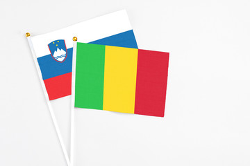 Mali and Slovenia stick flags on white background. High quality fabric, miniature national flag. Peaceful global concept.White floor for copy space.