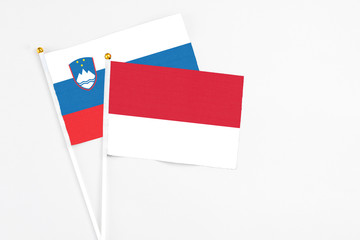 Monaco and Slovenia stick flags on white background. High quality fabric, miniature national flag. Peaceful global concept.White floor for copy space.