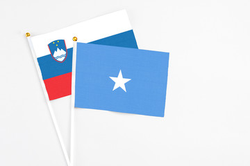 Somalia and Slovenia stick flags on white background. High quality fabric, miniature national flag. Peaceful global concept.White floor for copy space.