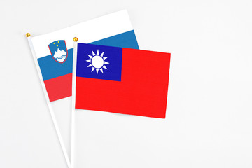 Taiwan and Slovenia stick flags on white background. High quality fabric, miniature national flag. Peaceful global concept.White floor for copy space.