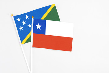 Chile and Solomon Islands stick flags on white background. High quality fabric, miniature national flag. Peaceful global concept.White floor for copy space.