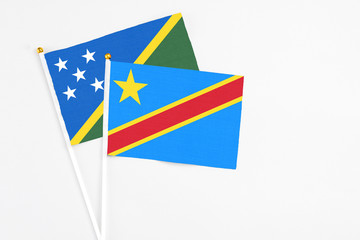 Congo and Solomon Islands stick flags on white background. High quality fabric, miniature national flag. Peaceful global concept.White floor for copy space.