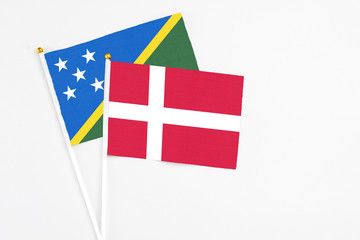 Denmark and Solomon Islands stick flags on white background. High quality fabric, miniature national flag. Peaceful global concept.White floor for copy space.