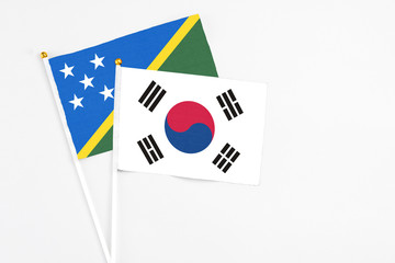 South Korea and Solomon Islands stick flags on white background. High quality fabric, miniature national flag. Peaceful global concept.White floor for copy space.