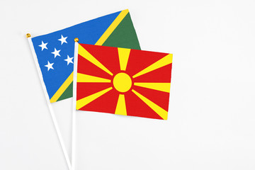 Macedonia and Solomon Islands stick flags on white background. High quality fabric, miniature national flag. Peaceful global concept.White floor for copy space.