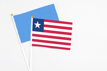 Liberia and Somalia stick flags on white background. High quality fabric, miniature national flag. Peaceful global concept.White floor for copy space.