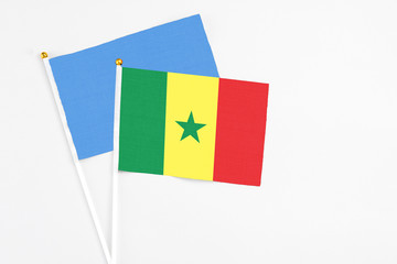 Senegal and Somalia stick flags on white background. High quality fabric, miniature national flag. Peaceful global concept.White floor for copy space.