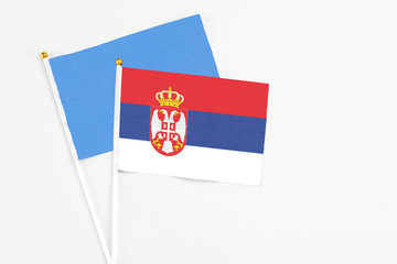 Serbia and Somalia stick flags on white background. High quality fabric, miniature national flag. Peaceful global concept.White floor for copy space.