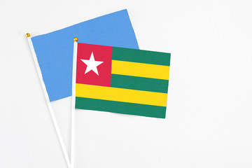 Togo and Somalia stick flags on white background. High quality fabric, miniature national flag. Peaceful global concept.White floor for copy space.