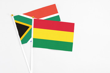 Bolivia and South Africa stick flags on white background. High quality fabric, miniature national flag. Peaceful global concept.White floor for copy space.