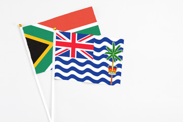 British Indian Ocean Territory and South Africa stick flags on white background. High quality fabric, miniature national flag. Peaceful global concept.White floor for copy space.