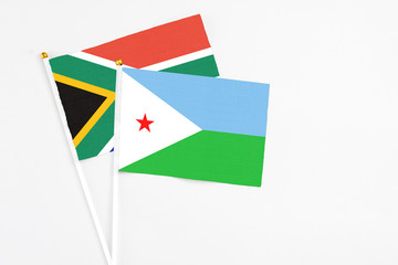 Djibouti and South Africa stick flags on white background. High quality fabric, miniature national flag. Peaceful global concept.White floor for copy space.