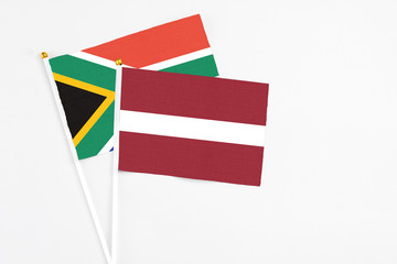 Latvia and South Africa stick flags on white background. High quality fabric, miniature national flag. Peaceful global concept.White floor for copy space.
