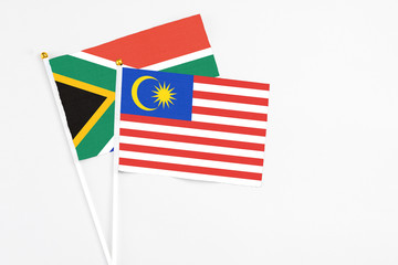 Malaysia and South Africa stick flags on white background. High quality fabric, miniature national flag. Peaceful global concept.White floor for copy space.