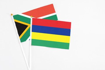 Mauritius and South Africa stick flags on white background. High quality fabric, miniature national flag. Peaceful global concept.White floor for copy space.