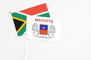 Mayotte and South Africa stick flags on white background. High quality fabric, miniature national flag. Peaceful global concept.White floor for copy space.