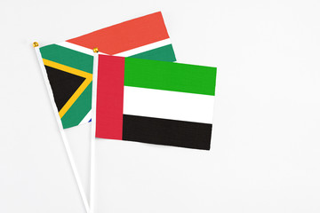 United Arab Emirates and South Africa stick flags on white background. High quality fabric, miniature national flag. Peaceful global concept.White floor for copy space.