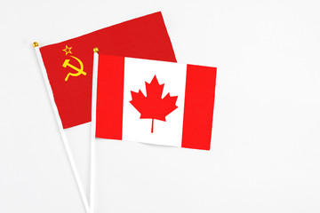 Fototapeta na wymiar Canada and Soviet Union stick flags on white background. High quality fabric, miniature national flag. Peaceful global concept.White floor for copy space.