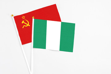 Nigeria and Soviet Union stick flags on white background. High quality fabric, miniature national flag. Peaceful global concept.White floor for copy space.