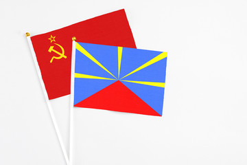 Reunion and Soviet Union stick flags on white background. High quality fabric, miniature national flag. Peaceful global concept.White floor for copy space.