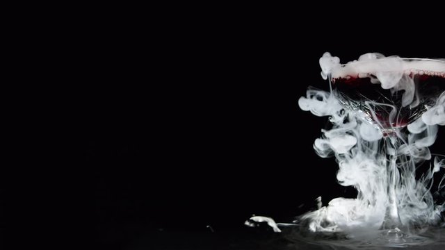 Smoking drink. Wine in a glass with dry ice. Halloween and nightlife concepts.. Please see forward and reserve variations. Shot on Red Camera, Slow mo, copy space.