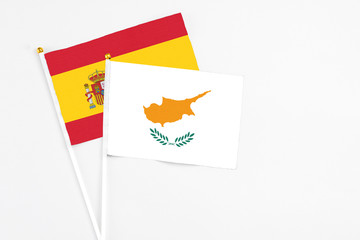 Cyprus and Spain stick flags on white background. High quality fabric, miniature national flag. Peaceful global concept.White floor for copy space.