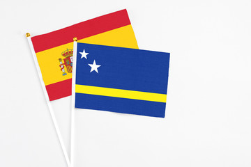 Curacao and Spain stick flags on white background. High quality fabric, miniature national flag. Peaceful global concept.White floor for copy space.